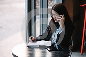 businesswoman talking on the phone and taking notes