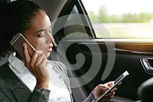 Businesswoman talking on a phone and using digital tablet