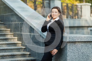 Businesswoman talking on phone while walking outdoor