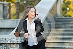 Businesswoman talking on phone while walking outdoor