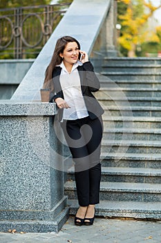 Businesswoman talking on phone while walking outdoor