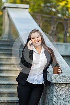 Businesswoman talking on phone while walking outdoor