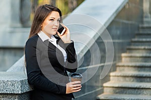 Businesswoman talking on phone while walking outdoor