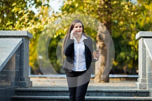 Businesswoman talking on phone while walking outdoor