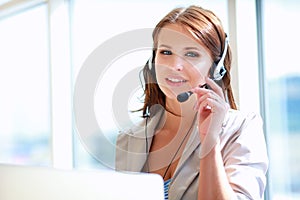 Businesswoman talking phone while working on her computer at the office