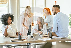 Businesswoman talking to her colleagues while gathering in the meeting room