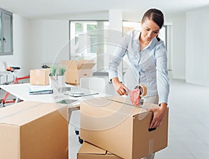 Businesswoman taping up a cardboard box