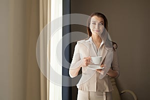 Geschäftsfrau Tee tasse auf der suche nach durch Büro 