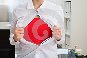 Businesswoman tearing her shirt showing red costume