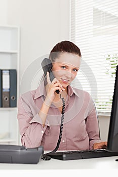 Businesswoman telephoning at workplace