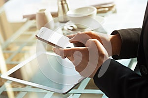 Businesswoman texting with her mobile during a coffee break