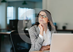 Businesswoman thinking about work while sitting at her office desk