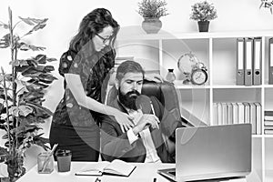 Businesswoman touching businessman working in office, workplace flirtation photo