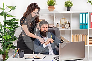 Businesswoman touching businessman working in office, workplace flirtation photo