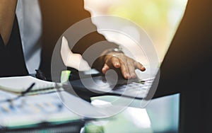 Businesswoman touching on laptop computer touchpad while working in office