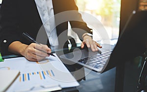 Businesswoman touching on laptop computer touchpad while working in office