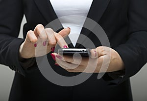 Businesswoman touching smartphone in her hands