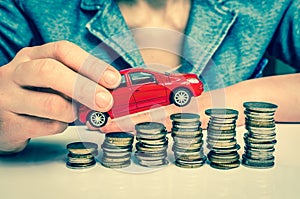 Businesswoman and toy car on coin stack - retro style