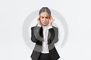 Businesswoman trying to focus, suffering migraine before important business meeting. Asian female entrepreneur touching