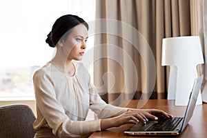 Businesswoman typing on laptop at hotel room