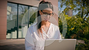 Businesswoman typing on laptop outdoors in city park smiling arabian business woman girl working remote studying using