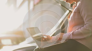 Businesswoman is typing on laptop outside.