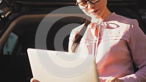 Businesswoman is typing on laptop outside.