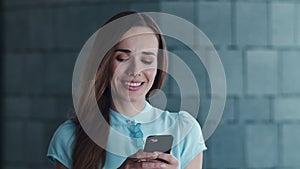 Businesswoman typing message on cellphone outside. Woman using smartphone