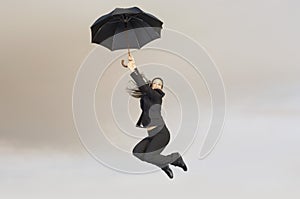 Businesswoman With An Umbrella In Midair photo