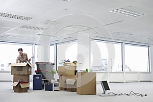 Businesswoman Unpacking Cartons In Office photo