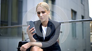 Businesswoman upset with message in smartphone, troubles at work, depression