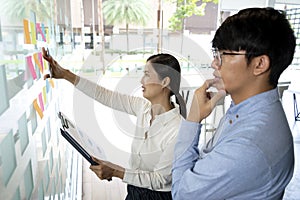 Businesswoman uses a pen in her hand to write a note on