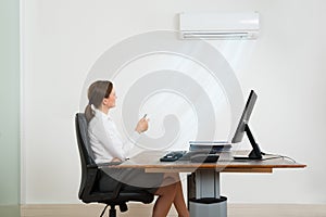 Businesswoman Using Air Conditioner In Office