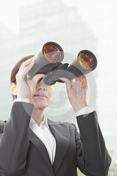 Businesswoman Using Binoculars Outside in Beijing