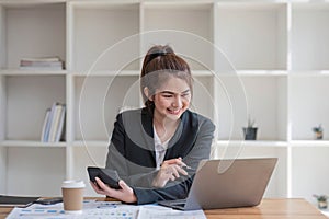 Businesswoman using calculator for do math finance on wooden desk in office and business working background, tax