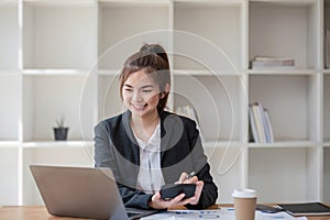 Businesswoman using calculator for do math finance on wooden desk in office and business working background, tax