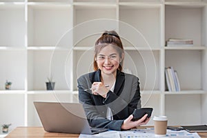 Businesswoman using calculator for do math finance on wooden desk in office and business working background, tax