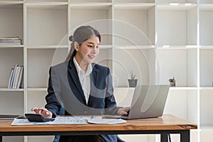 businesswoman using calculator for do math finance on wooden desk in office and business working background, tax