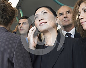 Businesswoman Using Cellphone In Crowd On Train