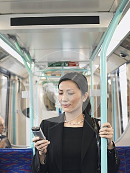 Businesswoman Using Cellphone In Train