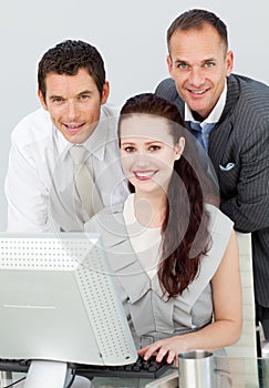 Businesswoman using computer with her colleagues