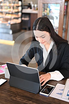 A businesswoman using computer tablet browsing financial website for checking banking exchange