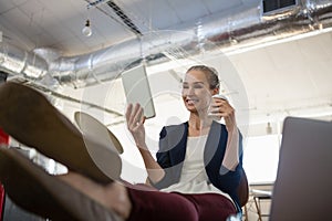 Businesswoman using digital tablet while relaxing