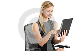 Businesswoman Using Digital Tablet While Sitting On Chair