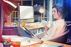 Businesswoman using digital tablet while sitting at desk