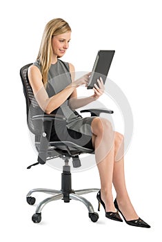 Businesswoman Using Digital Tablet While Sitting On Office Chair