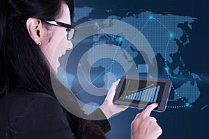 Businesswoman using digital touchpad on world map background photo