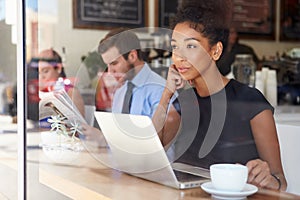 Businesswoman Using Laptop In Coffee Shop