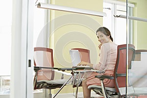 Businesswoman Using Laptop In Conference Room