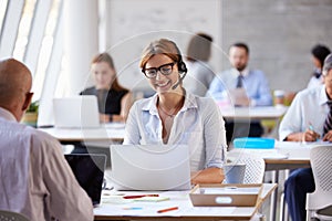 Businesswoman Using Laptop In Customer Service Department